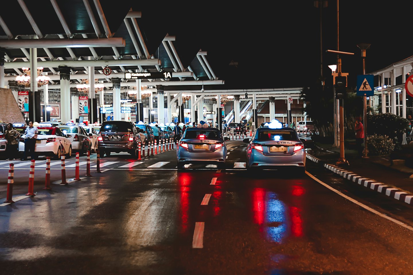 Angebot Taxis und Autos warten unter einem großen Terminaldach auf Fahrgäste.